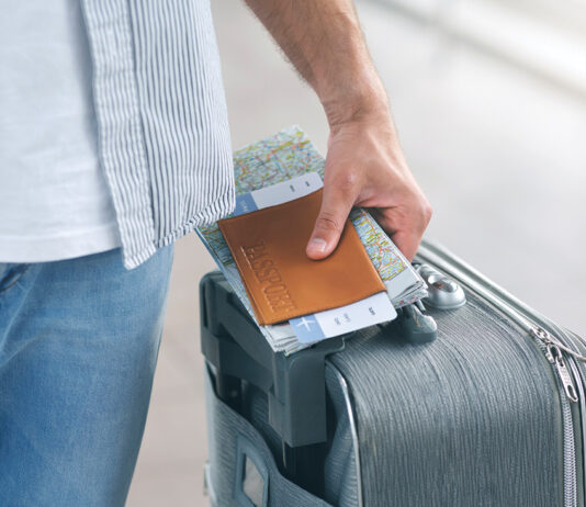 Man Holding His Passport And Carrying Suitcase, Close Up