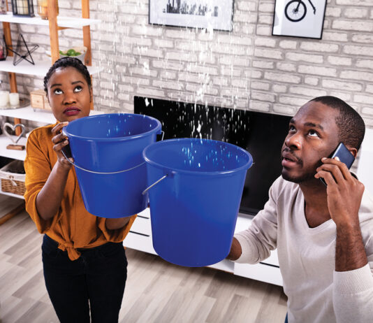 Couple Using Bucket For Collecting Water Leakage From Ceiling