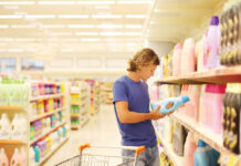 Man Shopping In Supermarket Reading Product Information.(washing Powder,detergent)